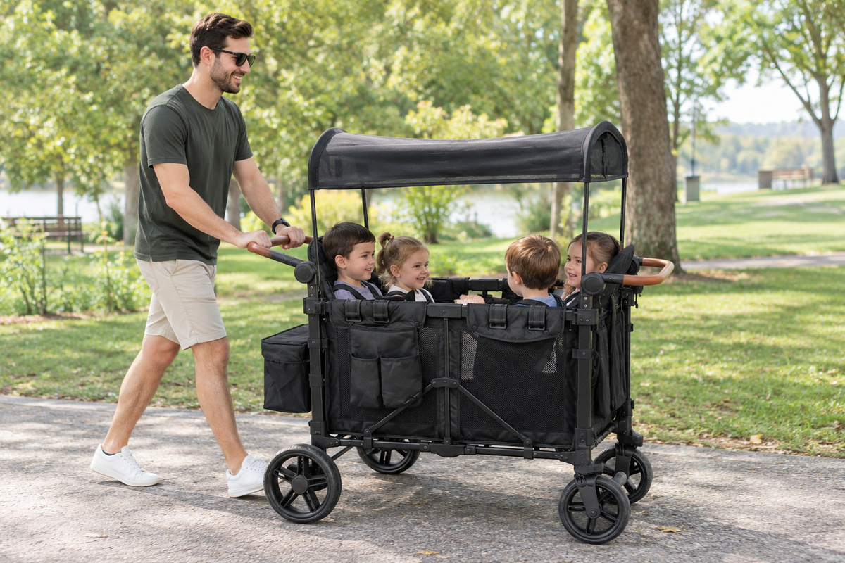 Man pushing a four-seat wagon stroller with four children through a park