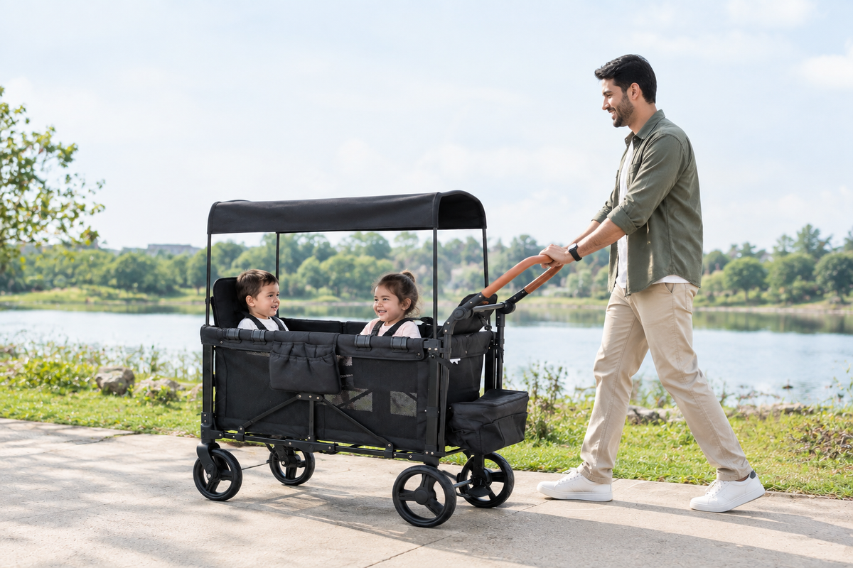 Father pushing a wagon stroller with two children by a lake.