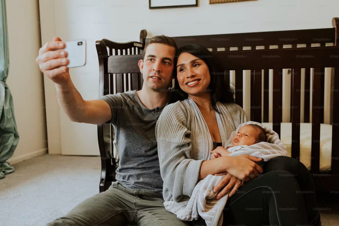 Parents taking a selfie with their newborn baby