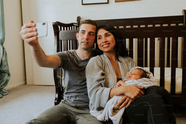 Parents taking a selfie with their newborn baby